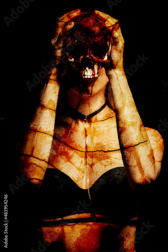 Woman holding bloody skull against dark background