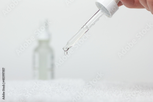 Closeup of a person using hyaluronic acid serum. 