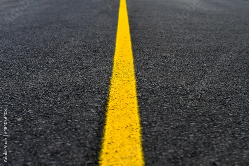 Yellow line on fresh asphalt to mark road works or temporary obstruction. 