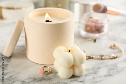 Composition with burning soy candles on white marble table