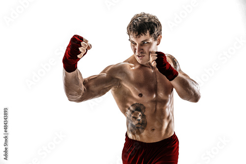 Studio shot of kickboxer who training, practicing uppercut on white background. Red sportswear