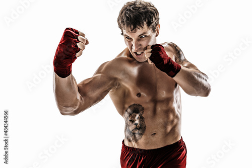 Portrait of aggressive boxer who training, practicing uppercut on white background. Red sportswear