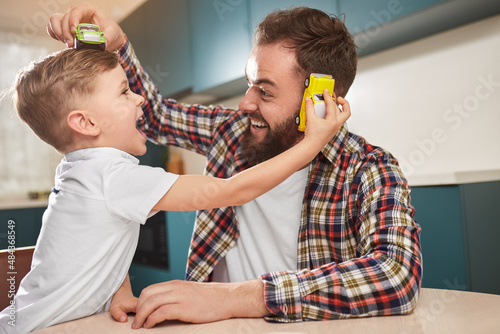 Father and son playing with toy cars