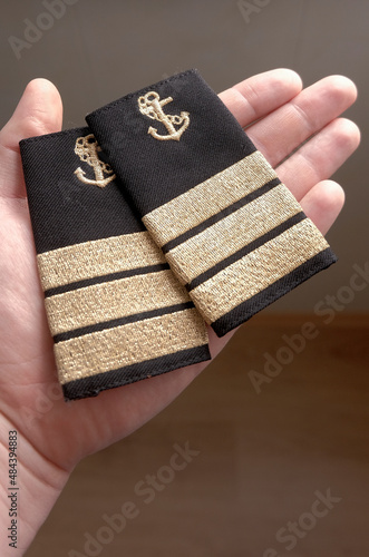 Chief Officer's marine epaulettes. Two pieces of shoulder straps in the male hand.