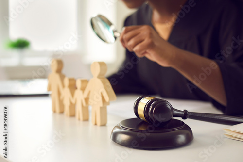 Crop close up of gavel on table of lawyer deal with family or matrimonial law. Juror with magnifier work with domestic relations cases in courthouse. Legislation and jurisdiction concept.