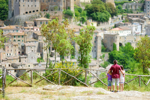 Family of three enjoying the view of Sorano, an ancient medieval hill town hanging from a tuff stone over the Lente River.
