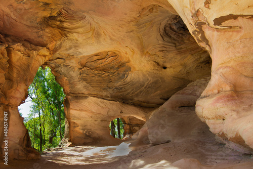 Views of the forest through an archway from inside sandstone caves in Pilliga Nature Reserve, near Coonabarabran, New South Wales, Australia.