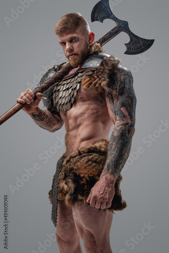 Violent viking with muscular build and axe on his shoulder