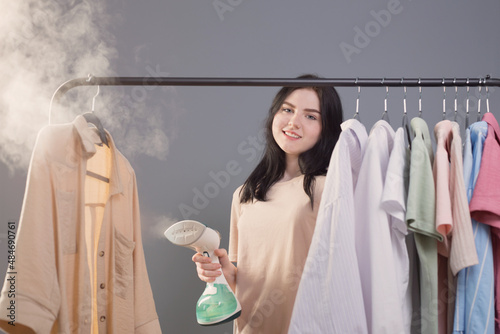 young brunette girl with steamer and clothes