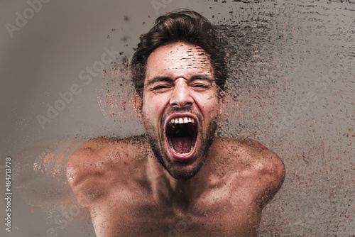 Screaming frustrated man exploding and disintegrating into particles, agonizing and torturing expression