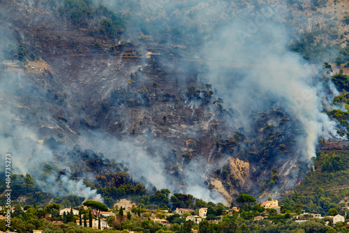 Fire in the forest mountain in the Italian town of Ventimiglia, all the mountains in the smoke, the villa is on fire, the fire service aircraft extinguish a fire