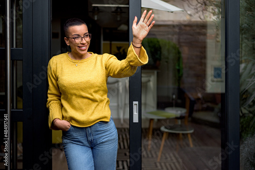 Cheerful happy satisfied smiling businesswoman or businessperson after a successful meeting. Adult person at the door of it's house greeting business partners or colleagues