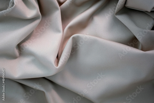 Fabric gray in folds top view. Close-up of the folds of the dress. Polyester folds texture.