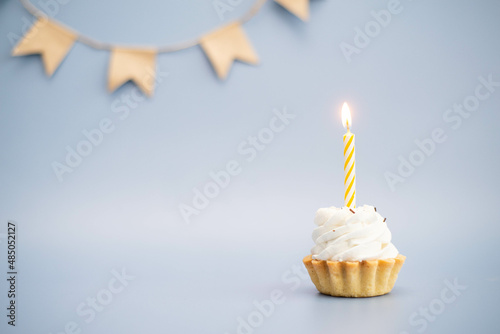 cake with yellow candle on a blue background