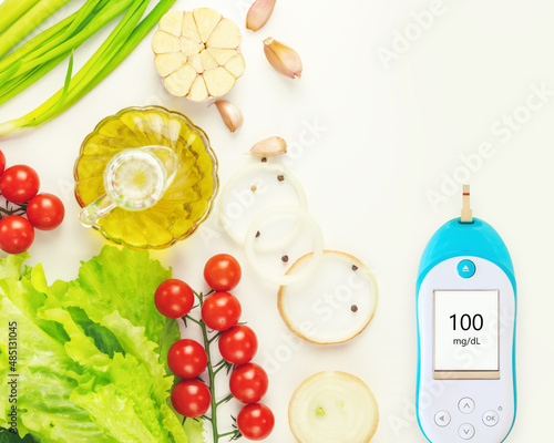 Diabetes control. Natural vegetables, olive oil and glucometer with the result of good glycemia on white background with copy space. Keto diet. Concept of no diabetes and control of glycemia with diet