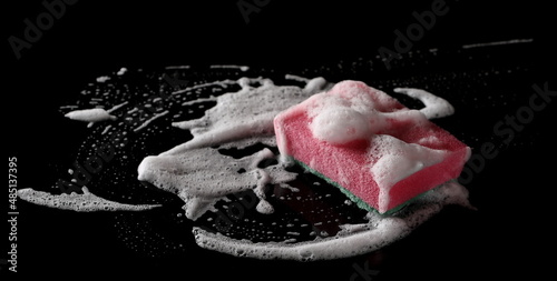 Soap foam with bubbles and sponge isolated on black 