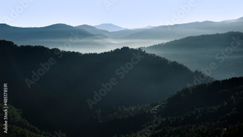 Montagnes dans la brume du soleil levant en hiver sur les forêts sauvages d'une vallée des Cévennes en France.