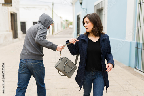 Man robbing a handbag from a scared woman