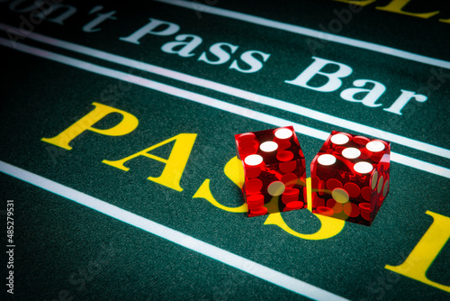 Professional casino-style dice sit on the pass section of a craps table.