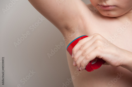 the teenager treats the armpit with dry deodorant to prevent excessive sweating