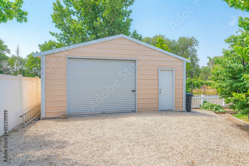 Detached gable garage exterior with steel walls and roll-up door with door latch lock