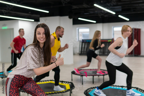 Women's and men's group on a sports trampoline, fitness training, healthy life - a concept trampoline group batut girl men, from fit activity for sporty and sport shaping, wellness happiness. Studio
