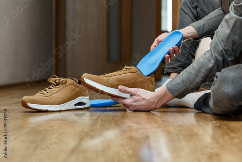 Man putting new custom insole in a shoe.