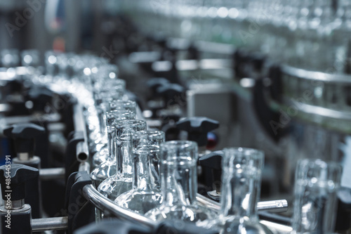 Production line transports empty glass bottles for alcohol