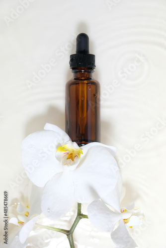 bottle of essential oil with white orchid