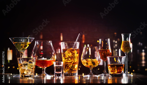 Assortment of hard strong alcoholic drinks and spirits in glasses on bar counter