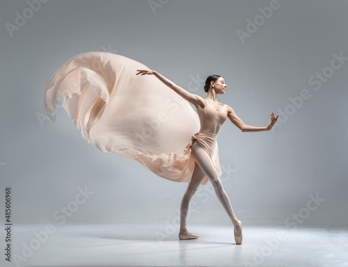 Beautiful ballerina dancing in the body color ballet leotard with body color cloth. She danced on ballet pointe shoes.
