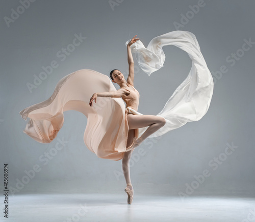 Beautiful ballerina dancing in the body color ballet leotard with body color cloth. She danced on ballet pointe shoes.