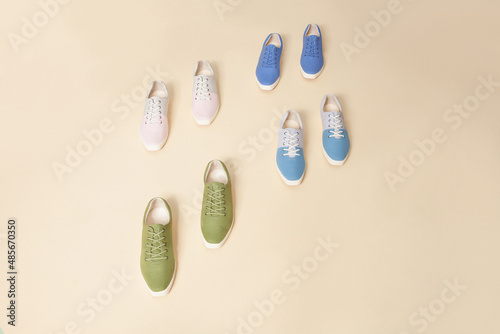 Stylish nature color sneakers isolated on beige background; space for text; top view