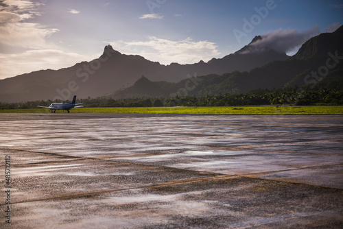 Airplane on the runway at the airport on the tropical island of Rarotonga at sunrise, Cook Islands