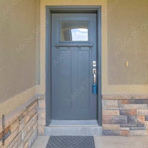 Square Front door exterior of a house with gray door and window