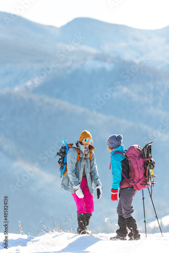 two women climbed to the top of the mountain during a winter hike