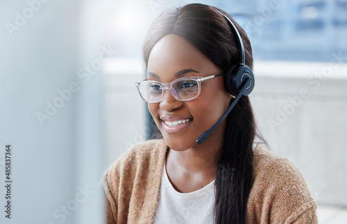 Hi there how may we help you today. Shot of a businesswoman sitting at her desk in a call center office.