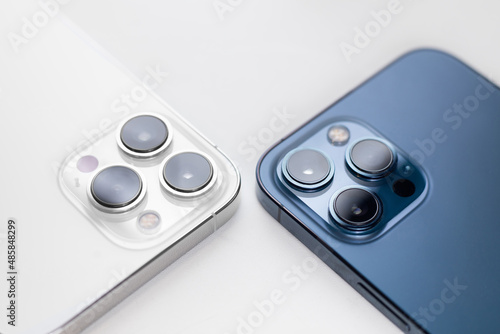 white and blue smartphone lies with cameras up on a white background