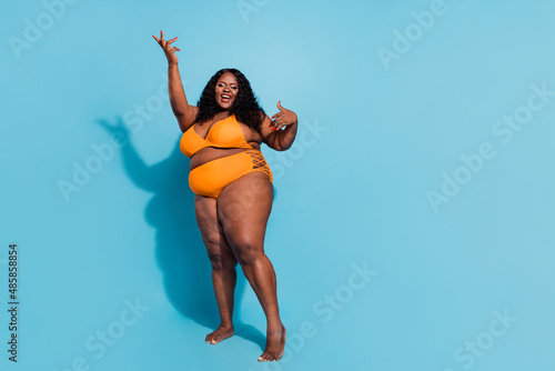 Full length photo of big chubby lady conscious her body dance season weekend discotheque isolated over blue color background