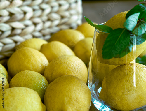 Glass with lemons for home mede lemonade, summer refreshment beverage concept, peppermint, wooden rustic background