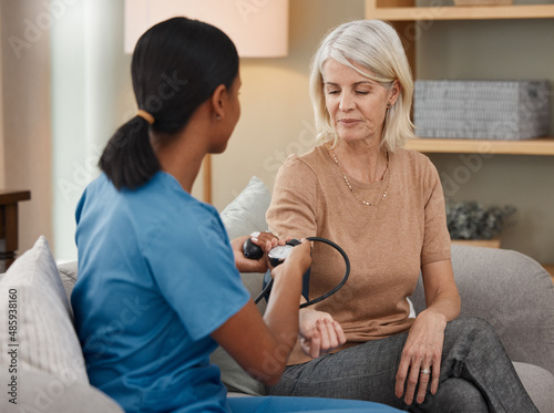 Lets hope my hypertension is under control. Shot of a doctor examining a senior woman with a blood pressure gauge at home.