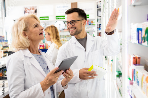Portrait of two pharmacist working in drugstore.