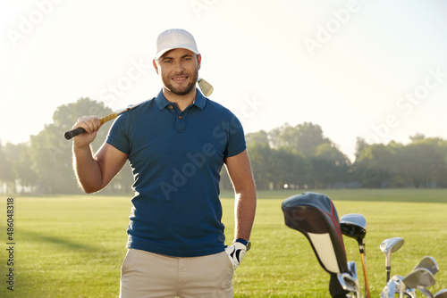 Golfer playing golf on green field at sunny day