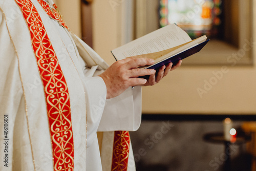 les mains du prêtre lisant la Bible