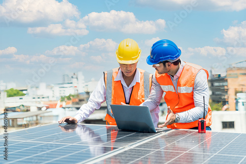 A technician or electrical engineer is teaching an apprentice to work. Foreman and Worker maintaining solar energy panel.