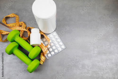 dumbbells on the background of pills. Healthy lifestyle. sports nutrition, doping
