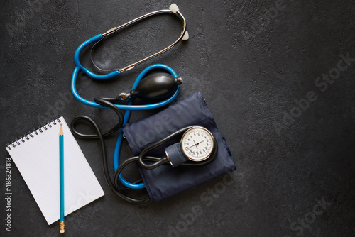 Diagnostic and monitoring concept, sphygmomanometer for measuring blood pressure and notebook for recording data, black background with space for text