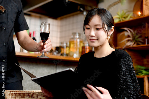 飲食店（レストラン）でワインを注文するアジア人の若い女性