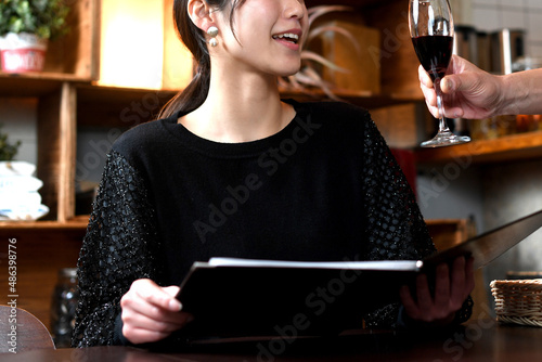 飲食店（レストラン）でワインを注文するアジア人の若い女性