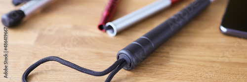 Sunglasses and stick for visually impaired lying on table closeup